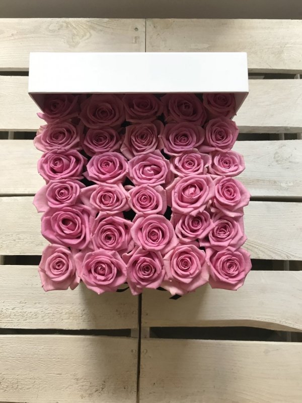 Różowe żywe róże w kwadratowym białym boxie