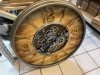 Zegar ścienny industrialny z widocznym mechanizmem zębatkowym, metalowa rama, drewniana tarcza, styl loftowy