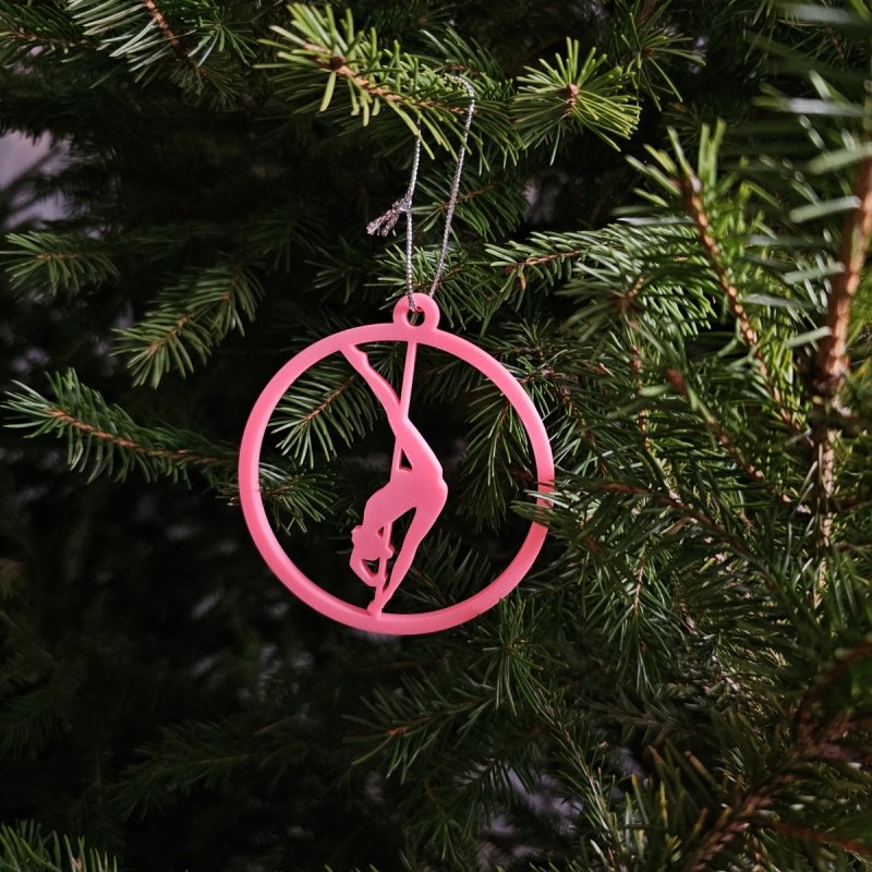Close-up of a Pink Glow in the Dark Pole Dance Ornament on a decorated Christmas tree branch. Amira Perun Xmas Decor