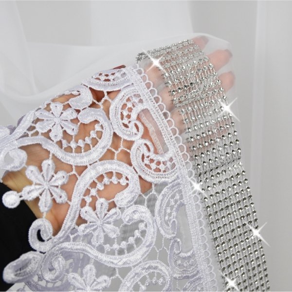 Efektowna szeroka gipiura i lśniące cyrkonie – detale wykończenia firany Diana.