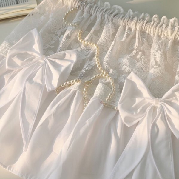 Widok na trzy duże ozdobne kokardy naszyte na łączeniu mikrofibry i tkaniny haftowanej.